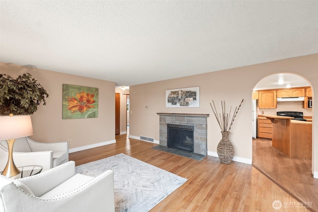 living room with light hardwood / wood-style floors and a textured ceiling