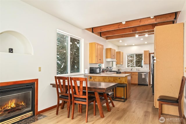 dining space with beam ceiling and light hardwood / wood-style floors