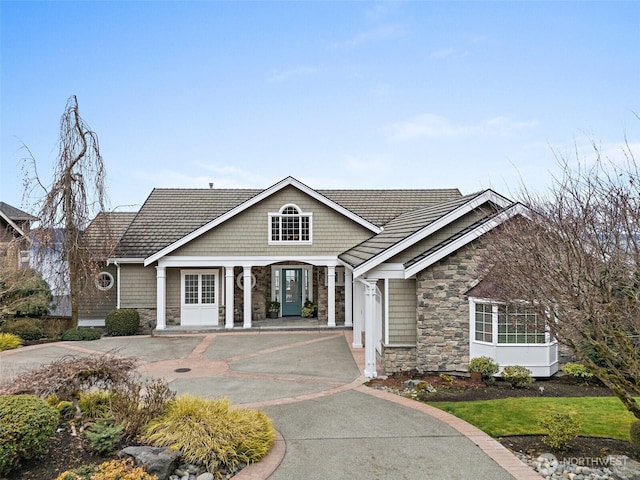 view of front of house featuring stone siding and driveway