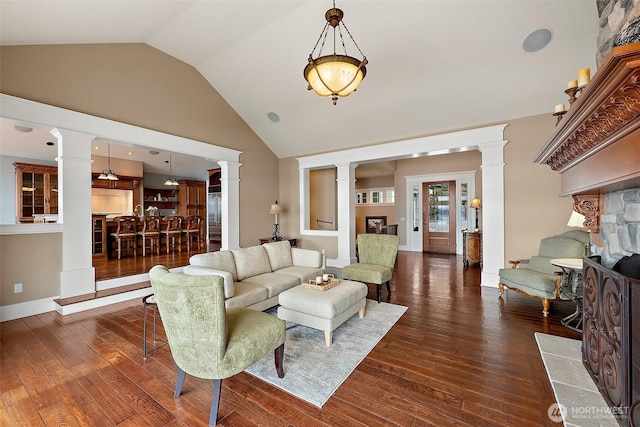 living area with high vaulted ceiling, ornate columns, and hardwood / wood-style floors