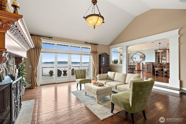 living area featuring hardwood / wood-style floors, decorative columns, and high vaulted ceiling