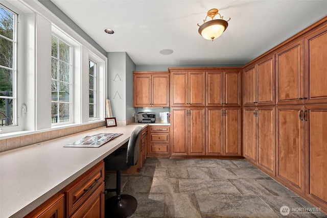 interior space featuring built in desk and stone finish floor