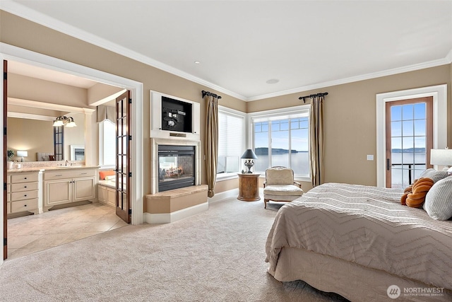 bedroom featuring crown molding, a multi sided fireplace, light colored carpet, ensuite bathroom, and a sink