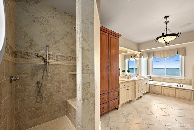 bathroom with tile patterned floors, a bath, vanity, and a tile shower