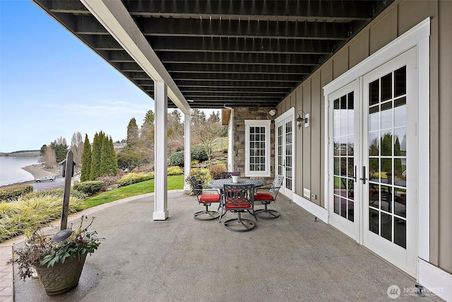 view of patio / terrace featuring french doors and a water view