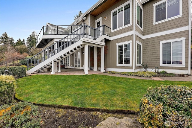 back of house featuring a patio area, board and batten siding, stairs, and a yard