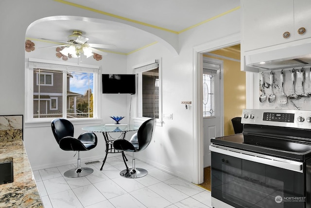 kitchen with crown molding, ceiling fan, light stone counters, and stainless steel range with electric stovetop