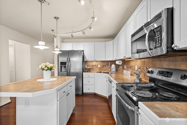 kitchen featuring sink, appliances with stainless steel finishes, hanging light fixtures, white cabinets, and a kitchen island