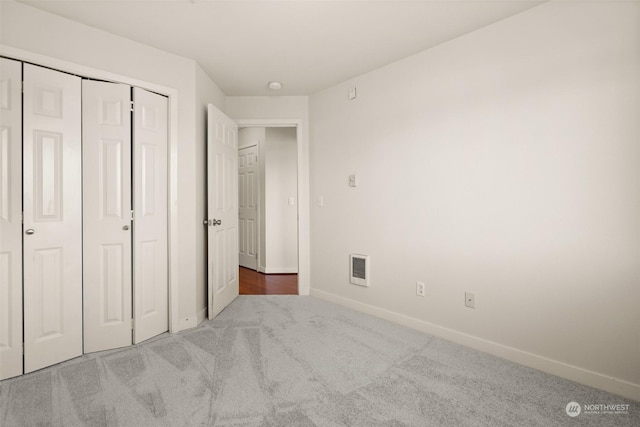 unfurnished bedroom featuring carpet flooring and a closet