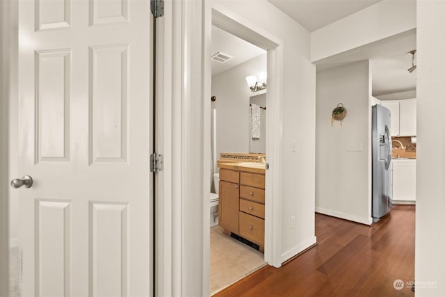 hallway featuring sink and light wood-type flooring