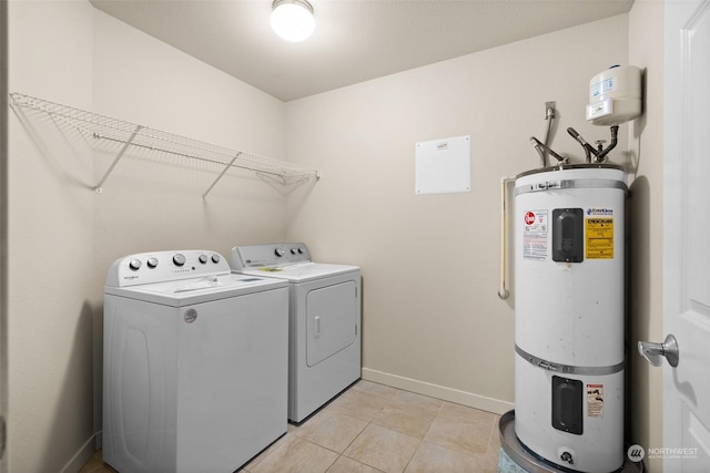 washroom with light tile patterned flooring, washer and clothes dryer, and strapped water heater