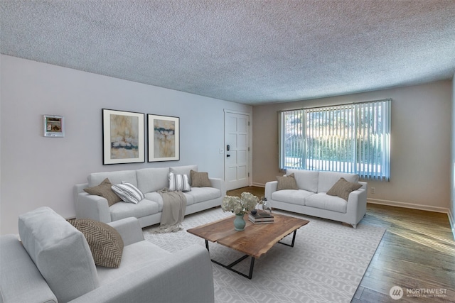 living area with a textured ceiling, wood finished floors, and baseboards