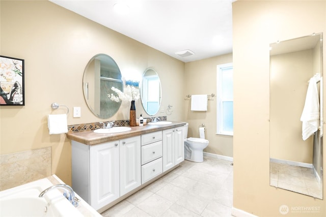 bathroom featuring a washtub, toilet, and vanity