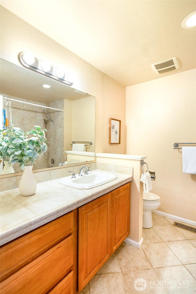 bathroom featuring toilet, tiled shower, a textured ceiling, tile patterned floors, and vanity