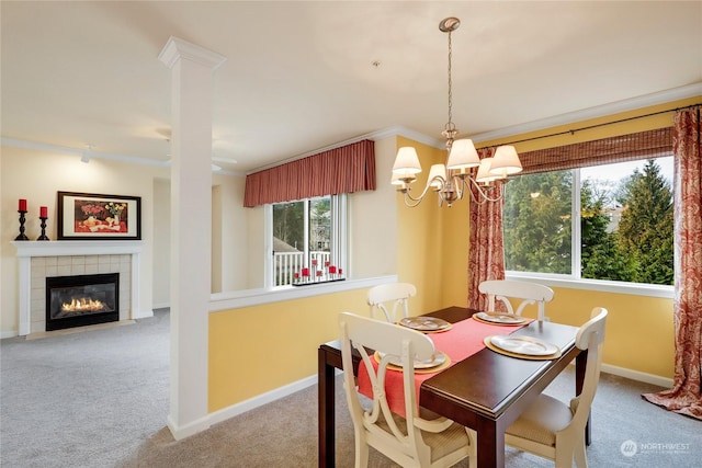 carpeted dining space featuring a tiled fireplace, ornamental molding, and an inviting chandelier