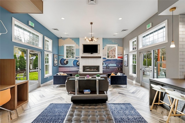 living room featuring an inviting chandelier, a towering ceiling, and light parquet floors