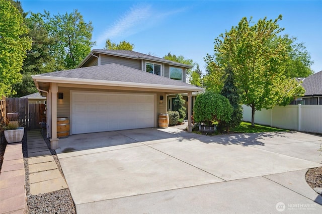 traditional home with driveway, a garage, a shingled roof, and fence