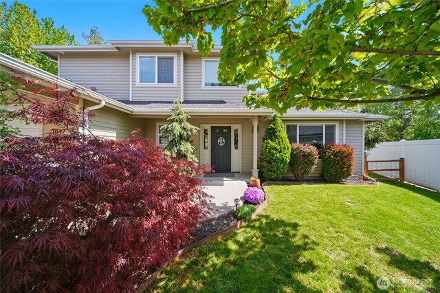 view of front facade with fence and a front yard