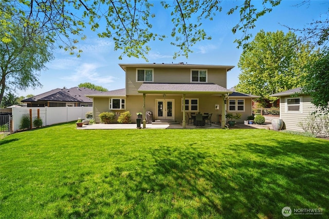 rear view of house with fence, french doors, a yard, and a patio area