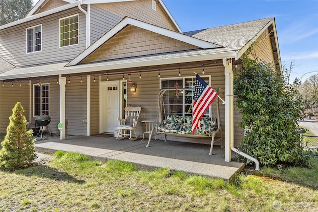 back of property featuring covered porch and roof with shingles