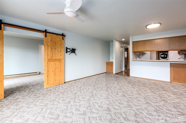 230 B St Unit 102, Friday Harbor, WA 98250 - unfurnished living room featuring a baseboard heating unit, carpet, a barn door, and washer / clothes dryer
