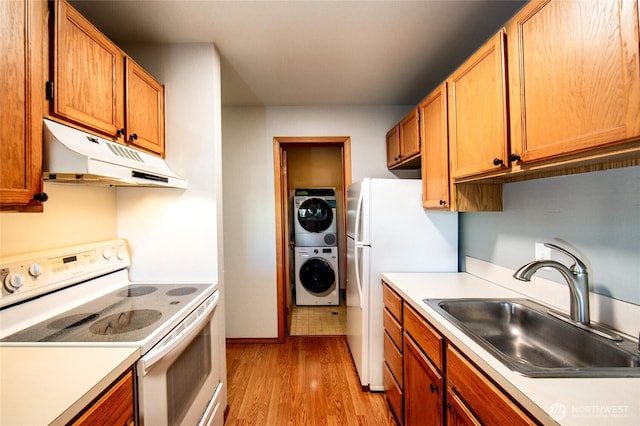 230 B St Unit 102, Friday Harbor, WA 98250 - kitchen featuring white appliances, stacked washer / dryer, under cabinet range hood, a sink, and light wood-style flooring