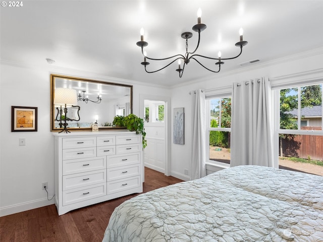 bedroom featuring dark hardwood / wood-style flooring, crown molding, and a chandelier