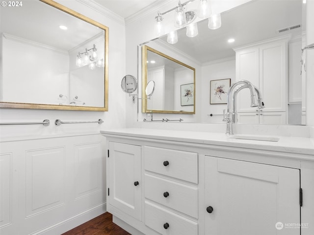 bathroom with hardwood / wood-style flooring, crown molding, and vanity