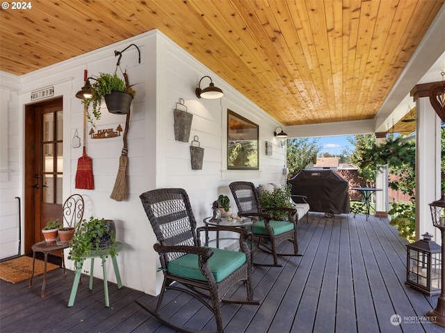 wooden terrace with a porch and a grill