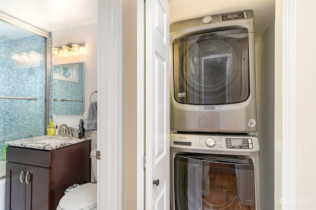 laundry room featuring stacked washer / drying machine and sink