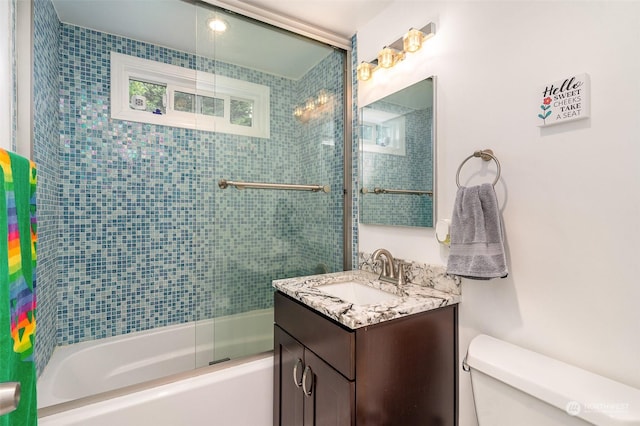 full bathroom featuring tiled shower / bath, vanity, and toilet