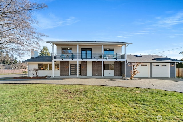 view of front of home featuring a balcony, a front yard, and french doors