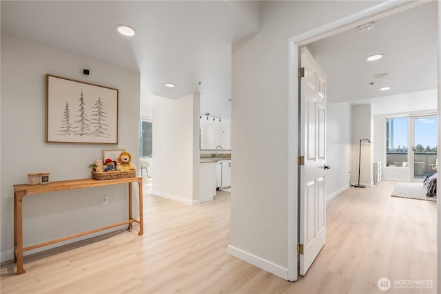 hall with sink and light wood-type flooring