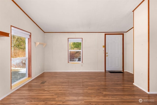 spare room featuring dark hardwood / wood-style flooring, crown molding, and a healthy amount of sunlight