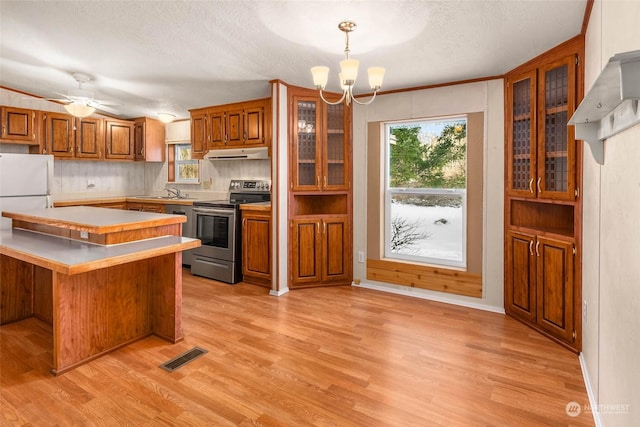 kitchen with pendant lighting, a kitchen bar, stainless steel range with electric cooktop, kitchen peninsula, and light wood-type flooring