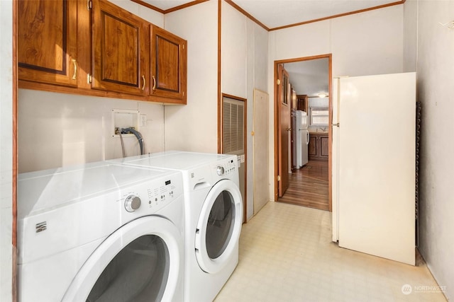 washroom with independent washer and dryer, ornamental molding, and cabinets