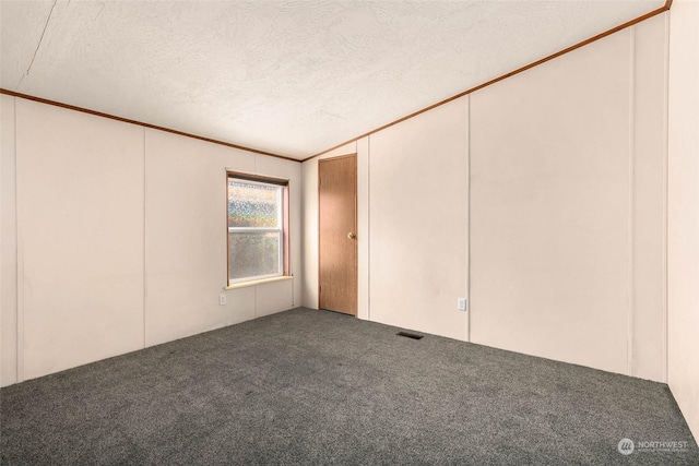 unfurnished room featuring ornamental molding, carpet, and a textured ceiling