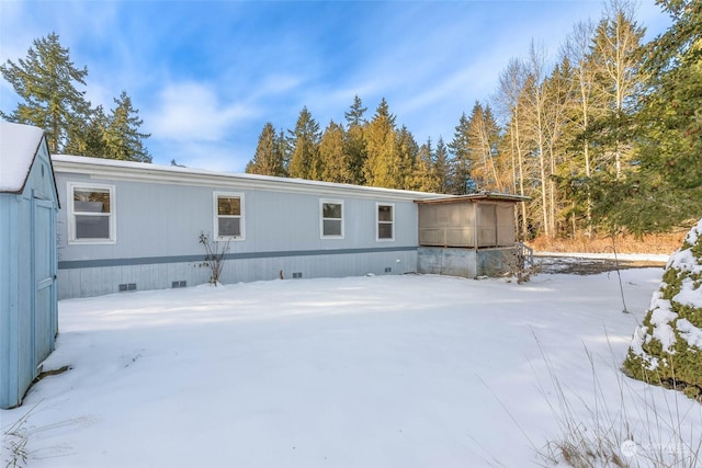 view of snow covered back of property