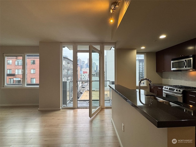 doorway featuring plenty of natural light, sink, and light hardwood / wood-style floors