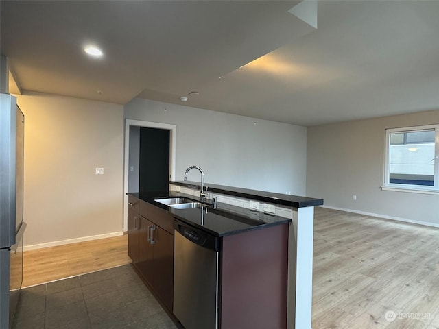 kitchen with sink, a center island with sink, fridge, stainless steel dishwasher, and light hardwood / wood-style floors