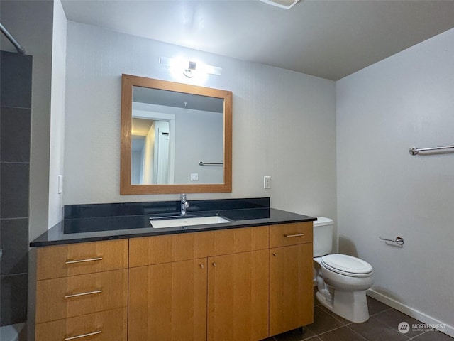 bathroom with tile patterned flooring, vanity, and toilet