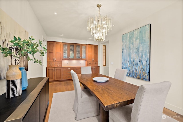 dining space with an inviting chandelier and light wood-type flooring