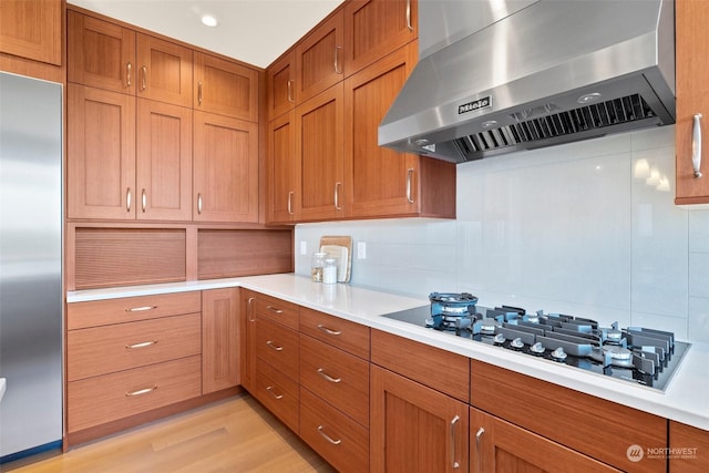 kitchen featuring white gas cooktop, extractor fan, decorative backsplash, and built in fridge