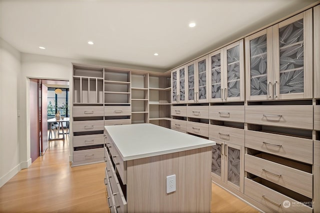 kitchen featuring light brown cabinets, a kitchen island, and light hardwood / wood-style flooring