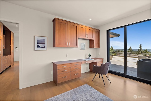 office area with built in desk and light hardwood / wood-style flooring