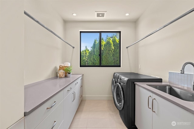 clothes washing area featuring cabinets, washer and clothes dryer, sink, and light tile patterned floors