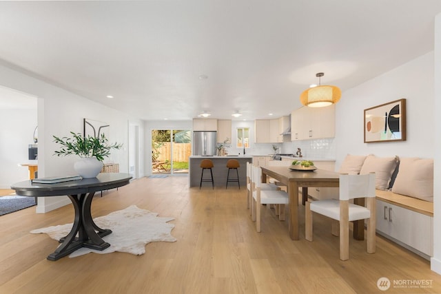 dining room with recessed lighting and light wood finished floors