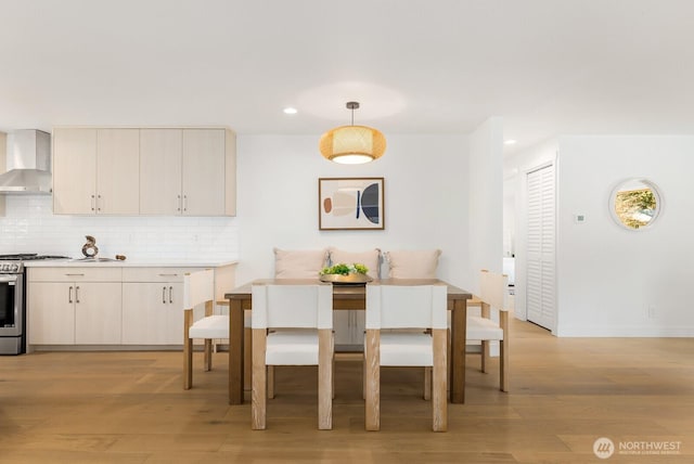 dining space with recessed lighting, light wood-style floors, and baseboards