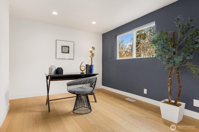 home office with visible vents, baseboards, and wood finished floors