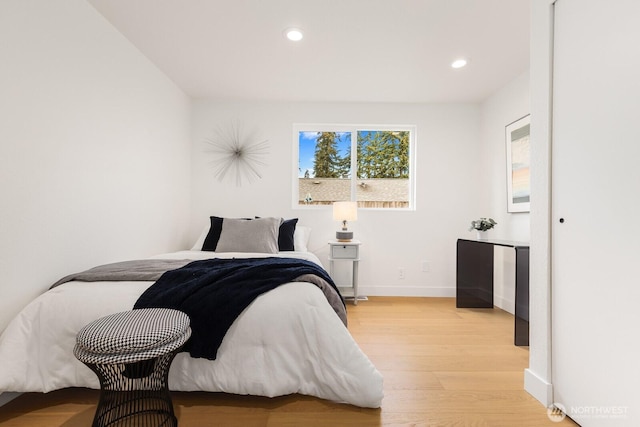 bedroom with recessed lighting, light wood-style floors, and baseboards